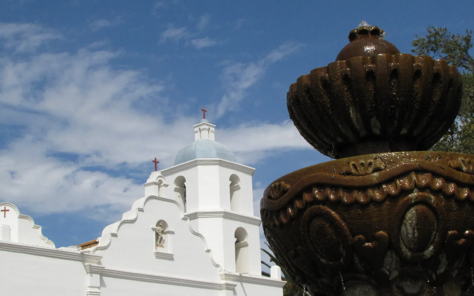 Mission San Luis Rey de Francia, a white mission church with bell towers and arched entrance in Spanish colonial architecture style